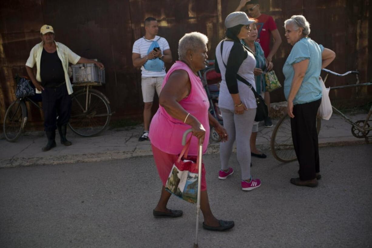 Pura Castell walks to a government-run butcher shop to buy chicken, after failing to find chicken the previous day in Bauta, Cuba, Friday, April 12, 2019. A neighbor informed her that chicken had arrived at the government store that distributes almost free monthly food rations.