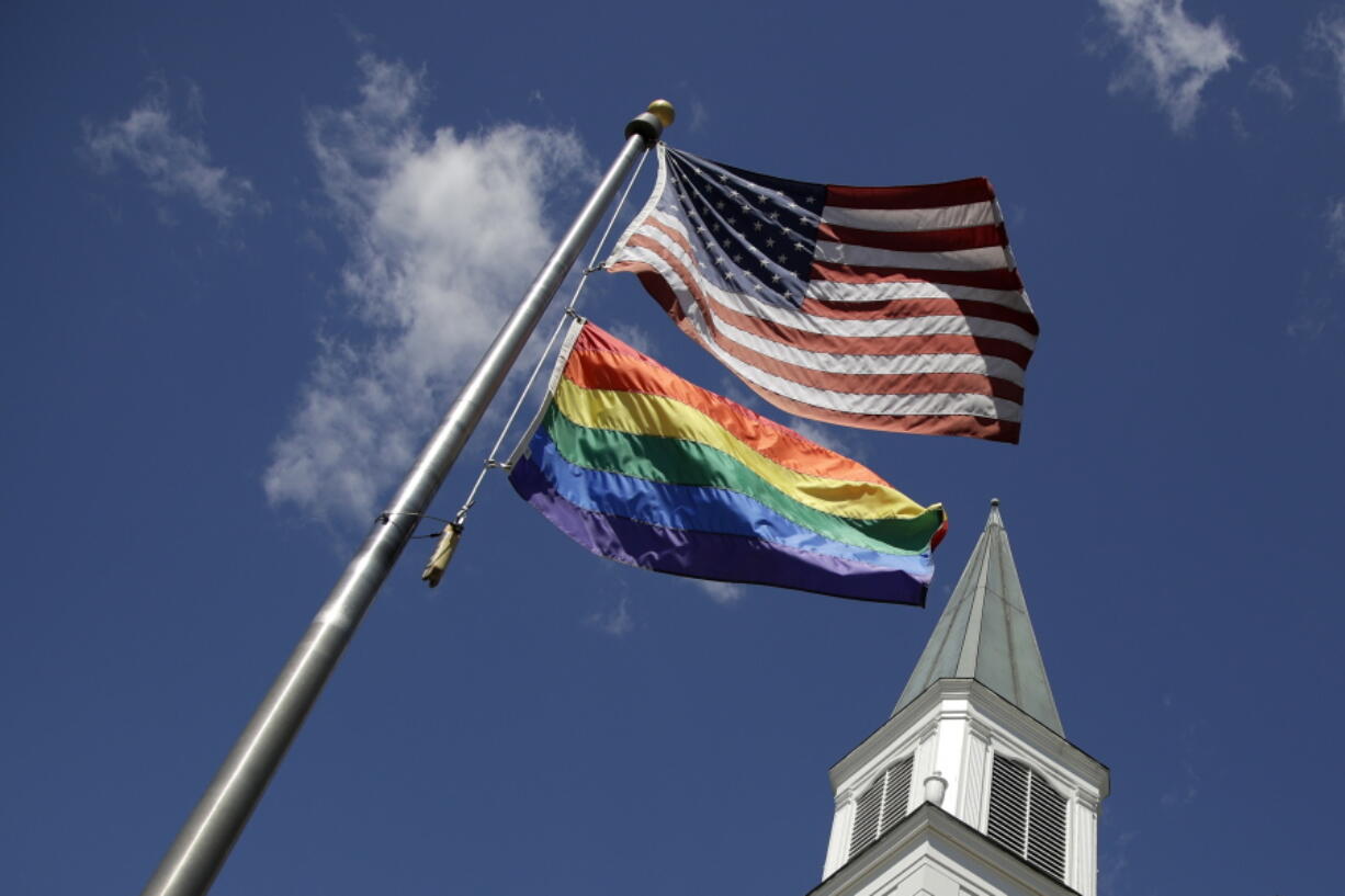 A gay pride rainbow flag flies along with the U.S. flag in front of the Asbury United Methodist Church in Prairie Village, Kan., on Friday.