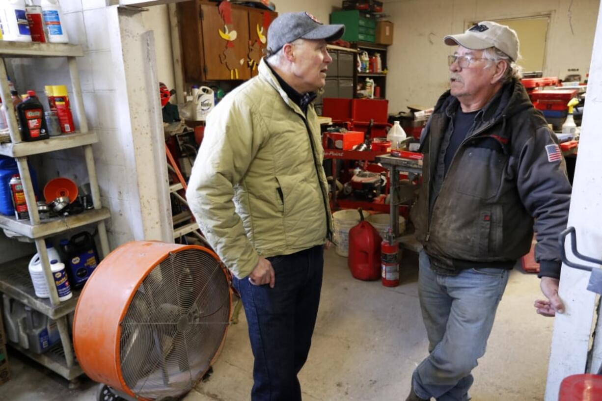 2020 Democratic presidential candidate Washington Gov. Jay Inslee talks with Ron Perry, of Hamburg, Iowa, right, while touring flood damage, Friday, April 12, 2019, in Hamburg, Iowa.