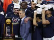 Virginia head coach Tony Bennett, center, celebrates with guard Ty Jerome, left, after the championship game against Texas Tech in the Final Four NCAA college basketball tournament, Monday, April 8, 2019, in Minneapolis. Virginia won 85-77 in overtime.