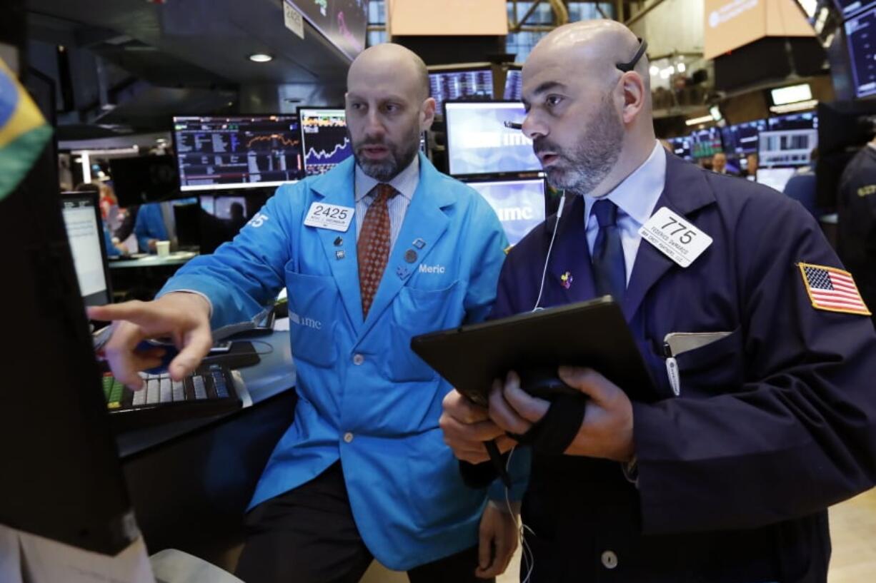 FILE- In this March 18, 2019, file photo specialist Meric Greenbaum, left, and trader Fred DeMarco work on the floor of the New York Stock Exchange. The U.S. stock market opens at 9:30 a.m. EDT on Monday, April 29.