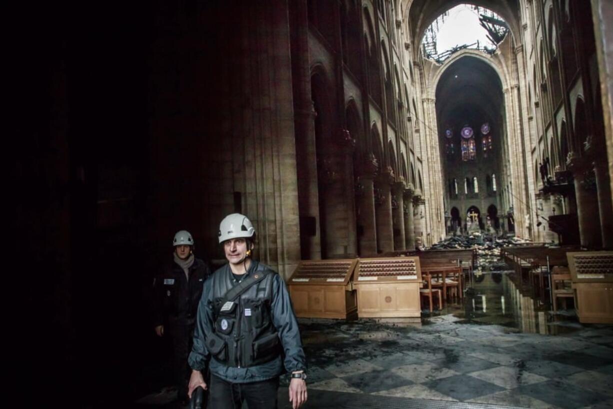 A man walks nside the damaged Notre Dame cathedral in Paris, Tuesday, April 16, 2019. Firefighters declared success Tuesday in a more than 12-hour battle to extinguish an inferno engulfing Paris’ iconic Notre Dame cathedral that claimed its spire and roof, but spared its bell towers and the purported Crown of Christ.