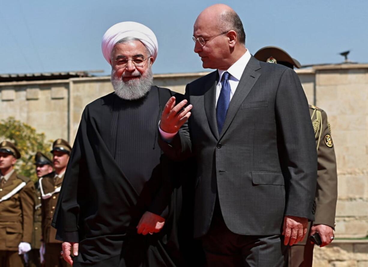 FILE - In this March 11, 2019 file photo, Iraqi President Barham Salih, right, walks with visiting Iranian President Hassan Rouhani, before their meeting at Salam Palace in Baghdad, Iraq. Iraq is seeking to reclaim a leadership role in the Arab world after decades of conflict. It is focusing on a centrist policy and its top leaders are determined to maintain good relations with both Iran and the United States.