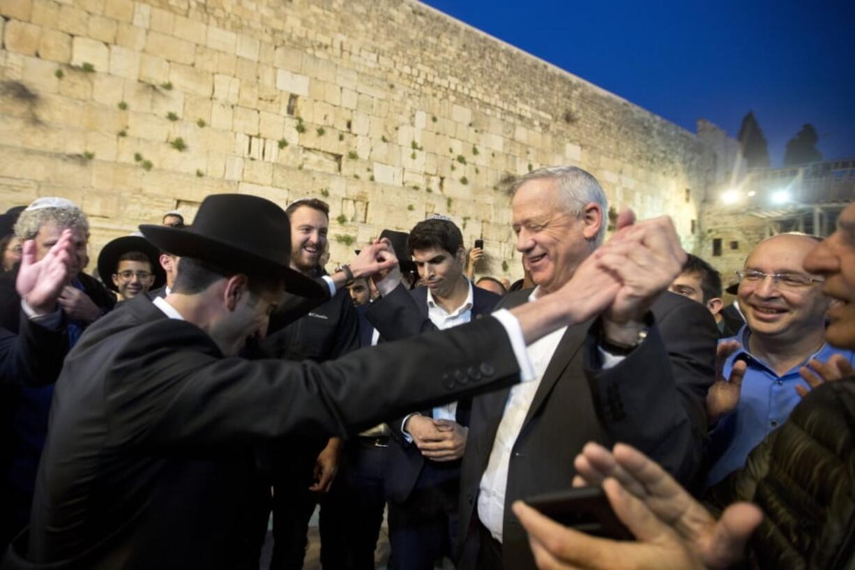 FILE - In this Thursday, March 28, 2019 file photo, leader of the Blue and White party, former Israeli army chief of staff, Benny Gantz dances with ultra Orthodox Jewish men at the Western Wall, in Jerusalem’s Old City. The conflict with the Palestinians has been a central issue in Israeli elections going back decades, but in the campaign ahead of next week’s vote it’s been notably absent. Prime Minister Netanyahu’s main challenger, Gantz, has given Israel’s “peace camp” some dim hope.