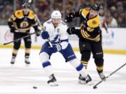 Tampa Bay Lightning’s Steven Stamkos (91) and Boston Bruins’ Matt Grzelcyk (48) battle for the puck during the first period of an NHL hockey game in Boston, Saturday, April 6, 2019.