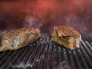 This Nov. 27, 2018 file photo shows steaks on a grill at a restaurant in New York. The idea behind the low-carb diet is that the body enters a ketogenic, fat-burning state when it runs out of the blood sugar that’s fueled by carbs. Still, many nutrition experts say sticking to a low-carb diet is hard, and not everyone is convinced it should be added to the dietary guidelines.