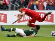 Toronto FC midfielder Marky Delgado (8) dives over Portland Timbers defender Jorge Moreira (2) as the two collide during the first half in Toronto, Saturday.