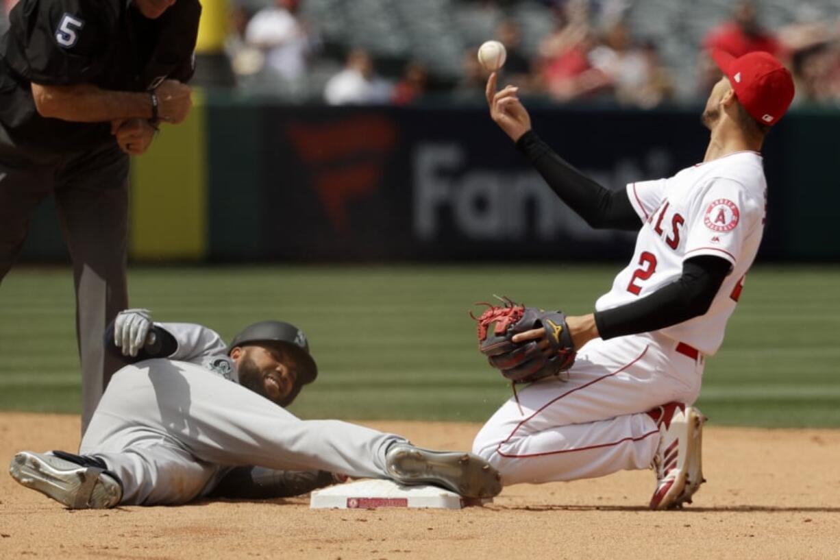 Los Angeles Angels shortstop Andrelton Simmons, right, tosses the ball after Seattle Mariners' Domingo Santana was tagged out trying to stretch a single into a double during the sixth inning of a baseball game in Anaheim, Calif., Sunday, April 21, 2019.