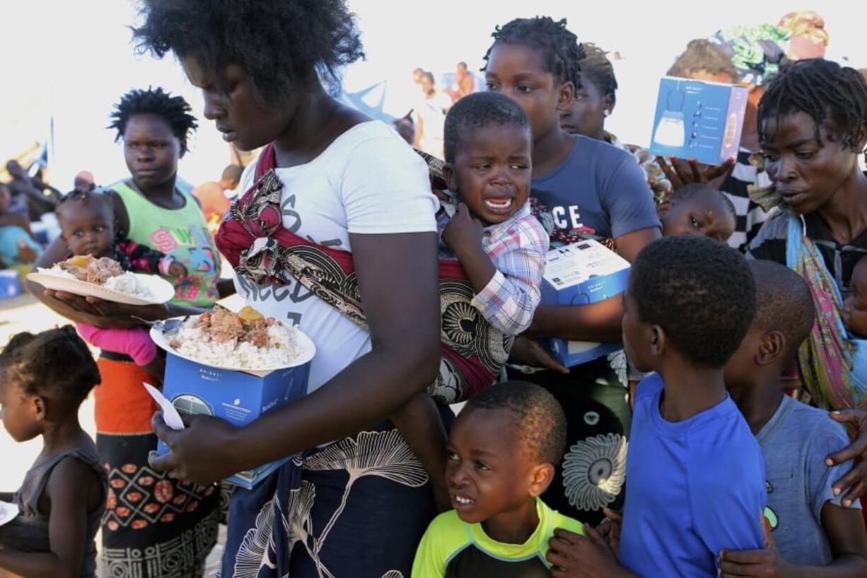 Women and children wait in line for food Tuesday at a camp for displaced survivors of Cyclone Idai in Beira, Mozambique.