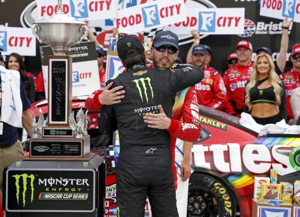 Kyle Busch, facing camera, gets a hug from brother Kurt Busch after winning the NASCAR Cup Series auto race Sunday, April 7, 2019, at Bristol Motor Speedway in Bristol, Tenn.