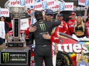 Kyle Busch, facing camera, gets a hug from brother Kurt Busch after winning the NASCAR Cup Series auto race Sunday, April 7, 2019, at Bristol Motor Speedway in Bristol, Tenn.