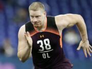 FILE - In this March 1, 2019, file photo, Washington offensive lineman Kaleb McGary runs a drill at the NFL football scouting combine in Indianapolis. McGary is a possible pick in the 2019 NFL Draft.