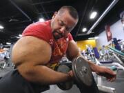 In this Nov. 16, 2012, file photo, Egyptian body builder Moustafa Ismail lifts free weights during his daily workout in Milford, Mass. On Monday, April 22, 2019, Merriam-Webster added the definition of swole to it’s online dictionary, with the meaning “extremely muscular: having a physique enhanced by bodybuilding exercises.” Ismail once was given the title of world’s biggest arms, biceps and triceps, by the Guinness Book of World Records.