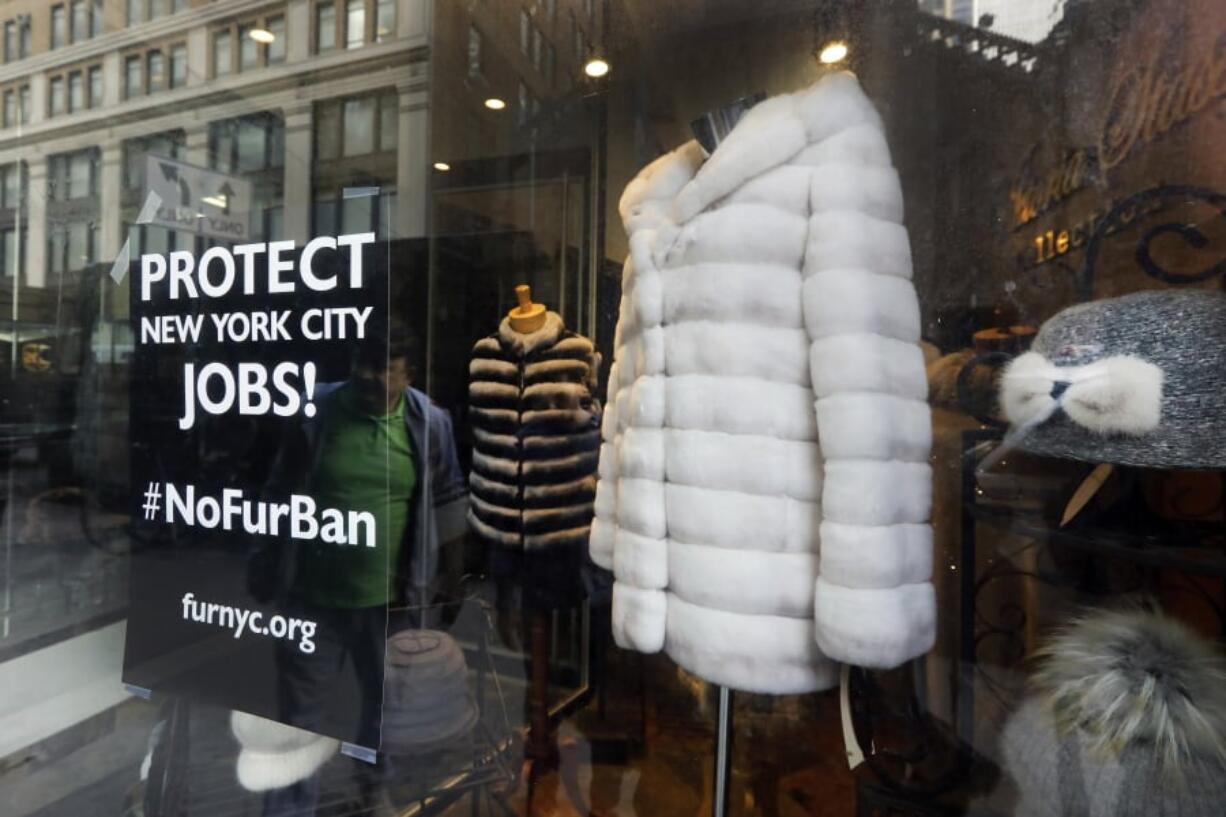 This April 10, 2019, photo shows a sign by furnyc.org in the window of Victoria Stass Collection in New York’s fur district. The fur trade is considered so important to New York’s development that two beavers adorn the city’s official seal, a reference to early Dutch and English settlers who traded in beaver pelts.