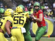 Oregon’s Justin Herbert, right, looks downfield on a pass play during an NCAA college spring football game.