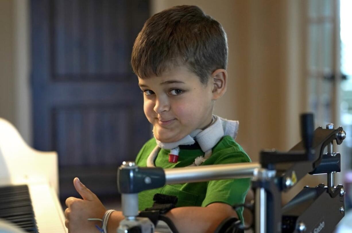 Braden Scott gives a thumbs up as he pauses while practicing on the piano in Tomball, Texas on Friday, March 29, 2019. Braden was diagnosed with the mysterious syndrome called acute flaccid myelitis, or AFM, in 2016 and was paralyzed almost completely. But since then he has recovered much of his muscle function. His parents believe a lot of it has to do with thousands of hours of physical therapy. (AP Photo/David J.