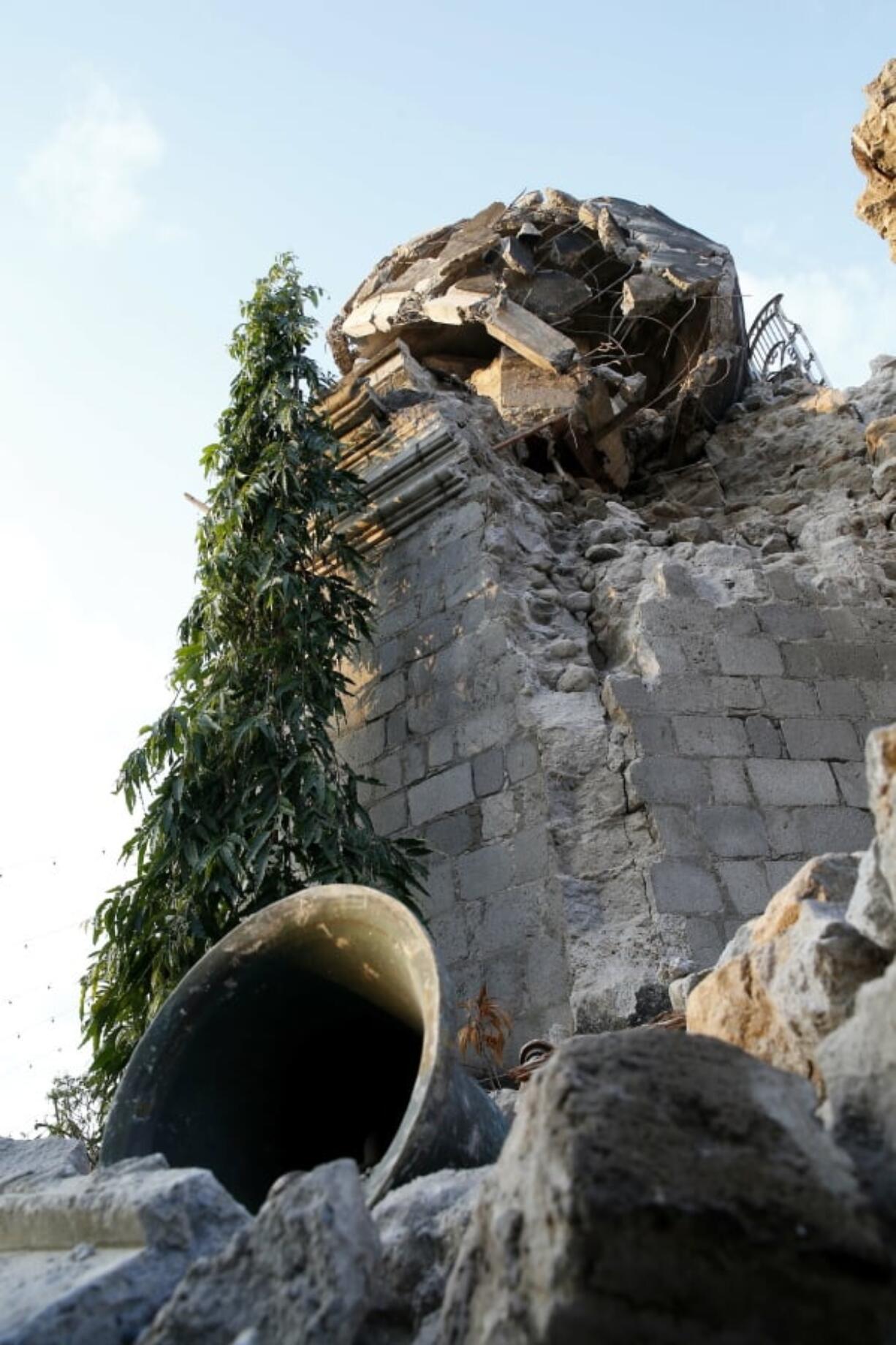 A bell sits in the rubble Tuesday after a 6.1 magnitude earthquake toppled the belfry of St. Catherine church Tuesday in Porac township, north of Manila, Philippines.