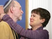 Daniel Leger, left, and Andrea Wedner, both survivors of the Tree of Life synagogue shooting, embrace after Pittsburgh Mayor Bill Peduto signed three gun-control bills into law, Tuesday, April 9, 2019, at the City-County Building in downtown Pittsburgh.