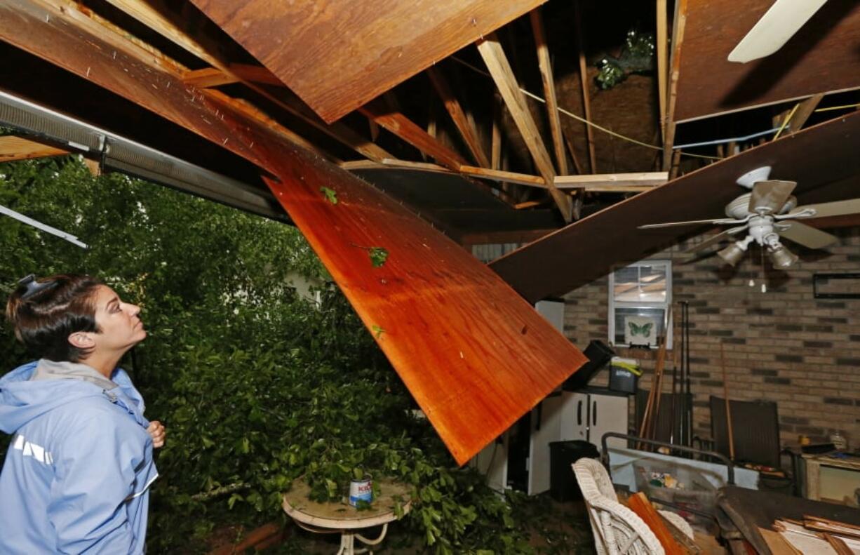 Sonya Banes looks at damage caused by a large oak tree that crashed through the ceiling of her mother’s house in Learned, Miss., Thursday, April 18, 2019. Several homes were damaged by fallen trees in the tree lined community. Strong storms again roared across the South on Thursday, topping trees and leaving more than 100,000 people without power across Mississippi, Louisiana and Texas. (AP Photo/Rogelio V.