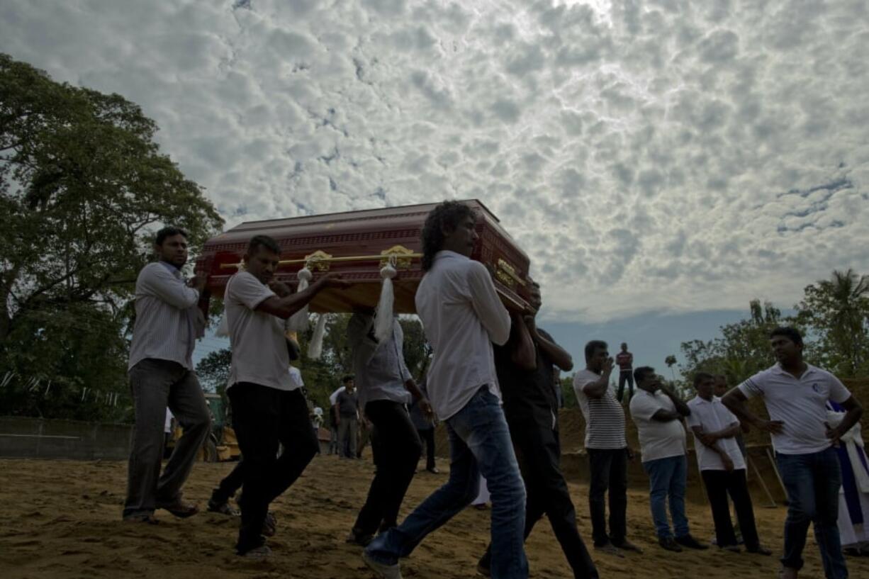 Relatives carry a coffin for burial during a mass burial for Easter Sunday bomb blast victims in Negombo, Sri Lanka, Wednesday, April 24, 2019.