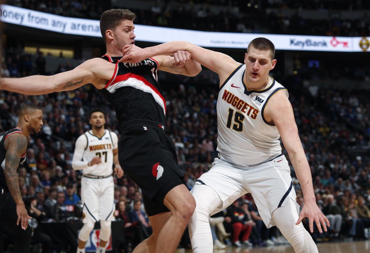 Denver Nuggets center Nikola Jokic, right, pushes off Portland Trail Blazers forward Meyers Leonard in the first half of Game 1 of an NBA basketball second-round playoff series Monday, April 29, 2019, in Denver.