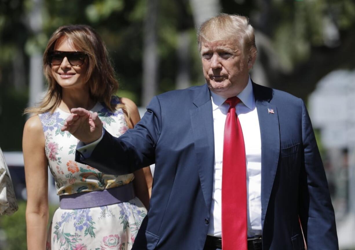 President Donald Trump, right, gestures as he and first lady Melania Trump, left, arrive for Easter services at Episcopal Church of Bethesda-by-the-Sea, Sunday, April 21, 2019, in Palm Beach, Fla.