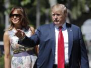 President Donald Trump, right, gestures as he and first lady Melania Trump, left, arrive for Easter services at Episcopal Church of Bethesda-by-the-Sea, Sunday, April 21, 2019, in Palm Beach, Fla.