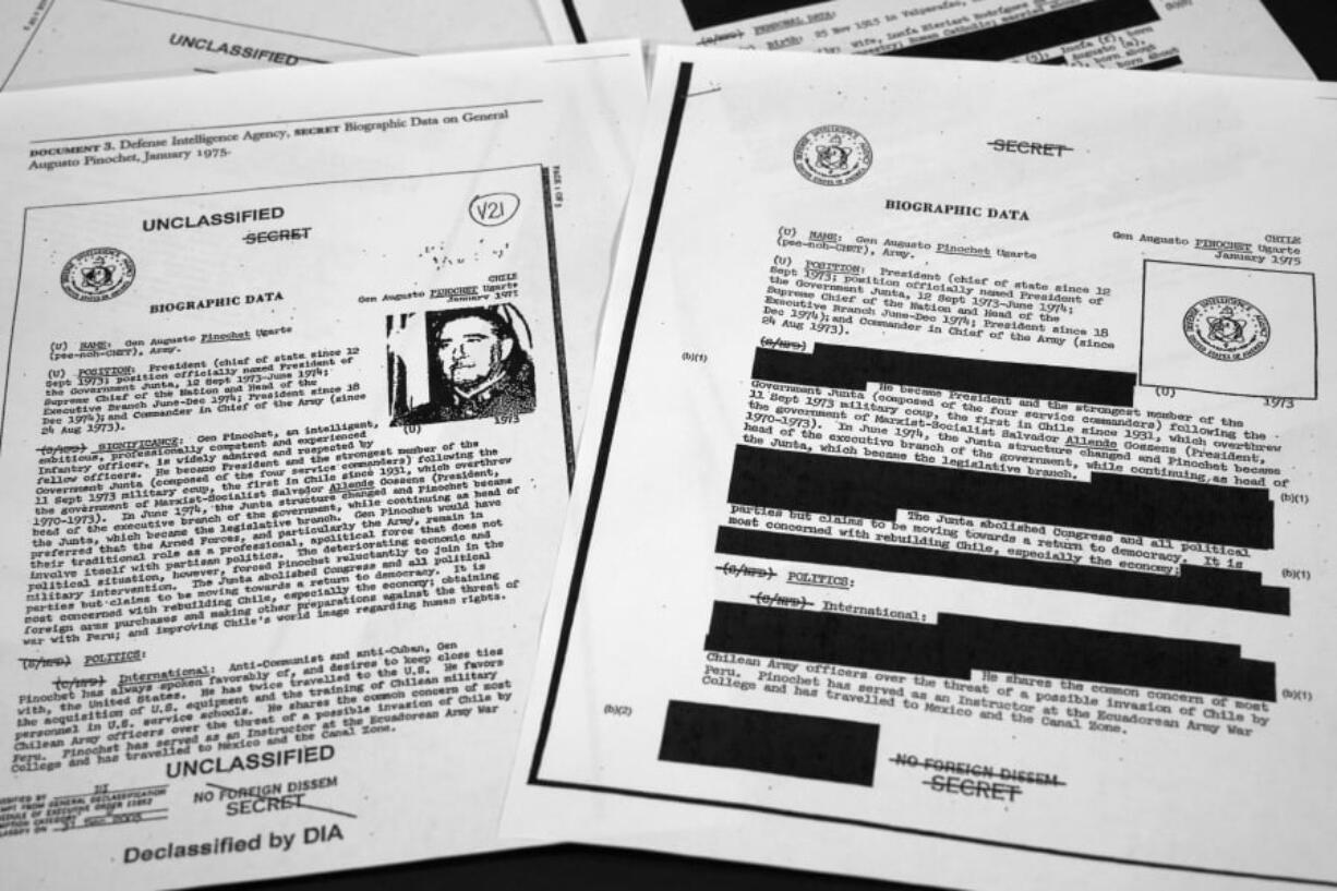 The redacted, right, and the unredacted versions of the biographical intelligence file report on Chilean dictator Augusto Pinochet from 1975 is photographed on April 15, 2019, in Washington. In 2003, the Defense Intelligence Agency declassified the documents that included a biographical sketch of Pinochet. Attorney General William Barr’s announcement that he would release a “redacted” version of Mueller’s findings will likely set off a long debate over what’s behind the darkened patches.