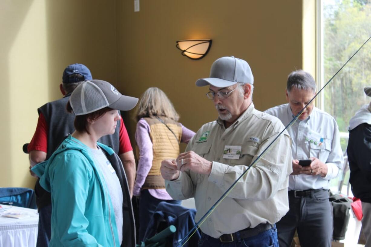 Clark-Skamania Flyfishers member Gene Reinert works with a student to assemble fly fishing gear. The beginners class is a way for people interested in fly fishing to learn about the gear, techniques, and ethics of the sport.