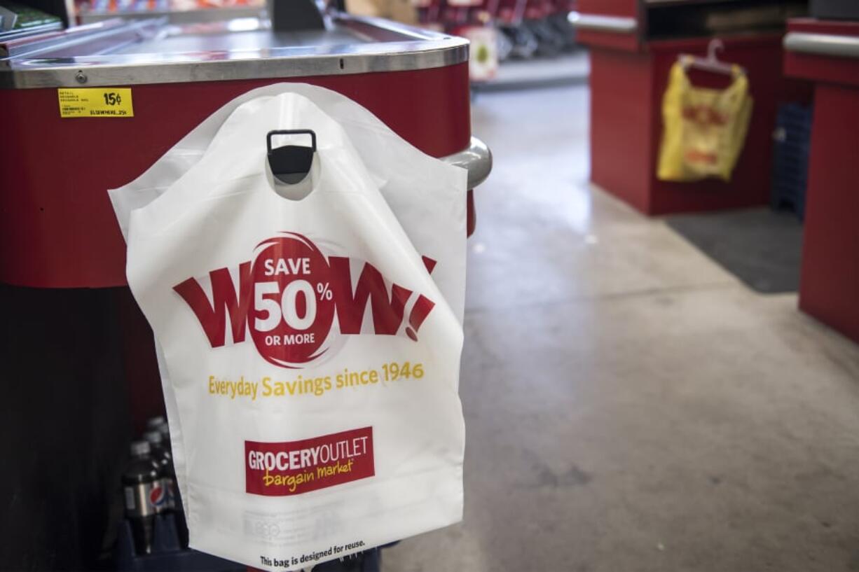 A reusable plastic bag is for sale at the end of a checkout counter at the Vancouver Grocery Outlet in March.