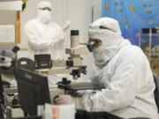 A technician at nLIGHT in Vancouver inspects a laser facet for defects under a microscope.