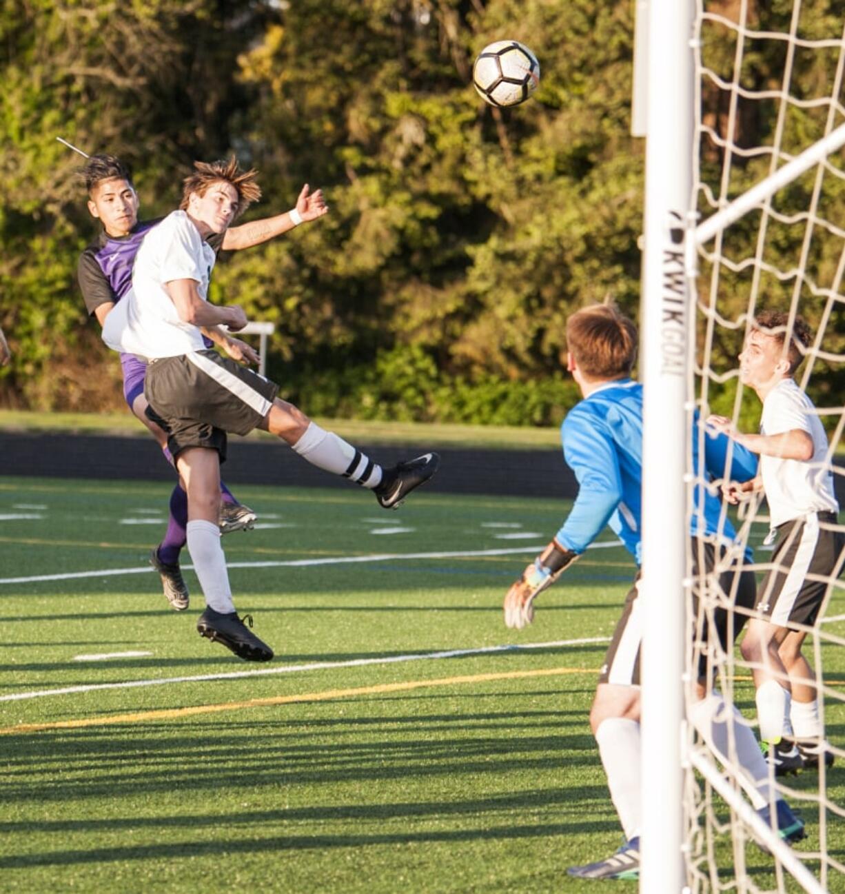 Columbia River's Julian Villa-Salas, left, admires his header over Woodland's Brooks Massey as the ball sails toward Woodland goalkeeper Treyson Thrall, who deflected it into the net. The goal put the Chieftains up 1-0 on the way to 3-0 victory Thursday at Chieftain Stadium in the 2A district championship.