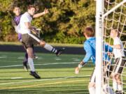 Columbia River's Julian Villa-Salas, left, admires his header over Woodland's Brooks Massey as the ball sails toward Woodland goalkeeper Treyson Thrall, who deflected it into the net. The goal put the Chieftains up 1-0 on the way to 3-0 victory Thursday at Chieftain Stadium in the 2A district championship.