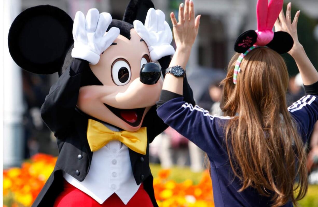 Walt Disney’s Mickey Mouse greets a visitor at Tokyo Disneyland in Urayasu city, Japan.