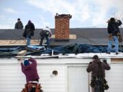 Workers replace a roof in Leesburg, Va.