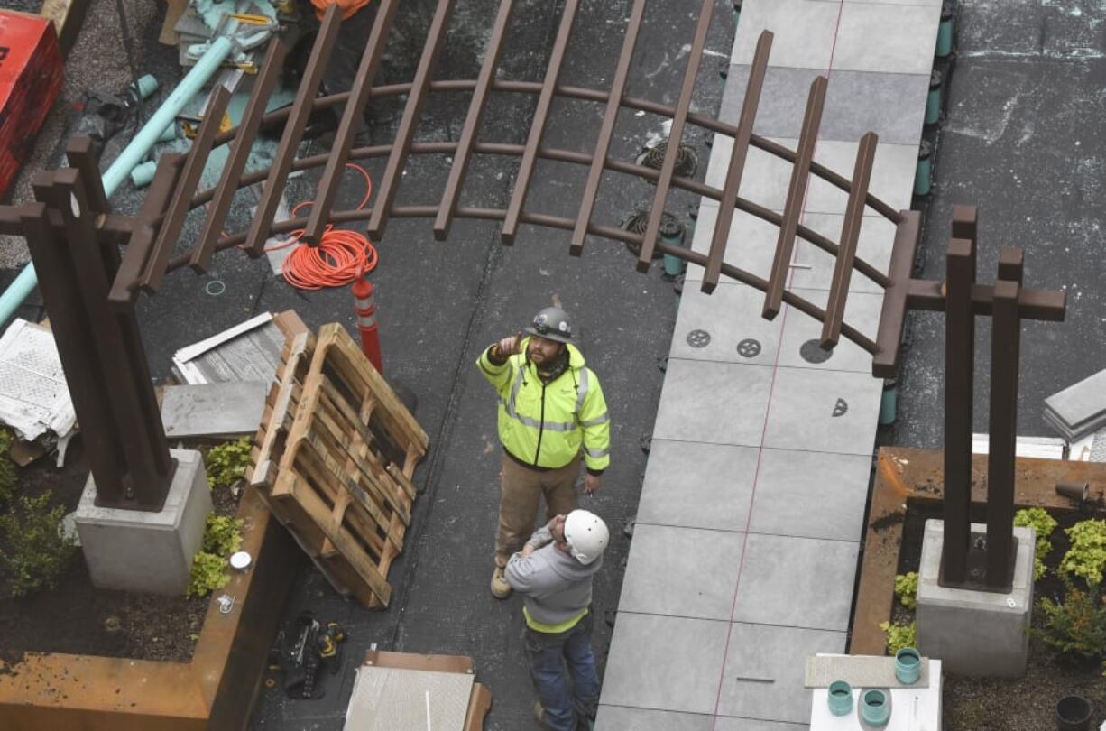 Workers look at a pergola in the courtyard at The Uptown Apartments in 2017.
