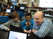 Burnt Bridge Creek Elementary fifth-graders Uriah Carlston, left, and Jonathan Suhajda work with volunteer Luke Loeffler on a CAD 3D-modeling program during the makerspace program at the school in Vancouver. The program brings in volunteers with different high-tech skills to share their knowledge with the students.