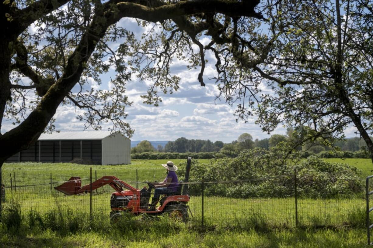 Kara Seaman drives a tractor through her Woodland Bottoms property. Seaman and many of her neighbors are worried about recent discussions in Woodland to expand the city’s urban growth boundary, which could result in developers building hundreds of new homes in the rural bottoms.