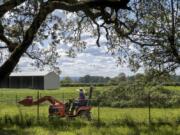 Kara Seaman drives a tractor through her Woodland Bottoms property. Seaman and many of her neighbors are worried about recent discussions in Woodland to expand the city’s urban growth boundary, which could result in developers building hundreds of new homes in the rural bottoms.