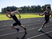 Prairie High School senior Nolan Mickenham, left, takes off as Zeke Dixson hands off to him during the 400-meter relay in Vancouver, Wash., on April 30, 2019.