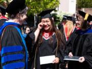 Roseanna Camacho, of Graham, fights back tears as she is presented with the College of Nursing Outstanding RN-BSN Student award by Linda Eddy, left, Academic Director and Associate Dean for the College of Nursing, and Vicki Denson, Clinical Assistant Professor and Assistant RN-BSN Director, during Washington State University Vancouver graduation ceremony at Sunlight Supply Amphitheater. “When you are a nurse, you are always giving, so to just get noticed for who you are is so amazing,” Camacho said about her award.