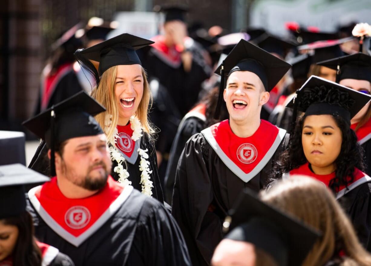 Hannah Ehlers, left, and Alec Roselle, both of Vancouver, line up with fellow graduates Saturday during the Washington State University Vancouver commencement ceremony at Sunlight Supply Amphitheater.