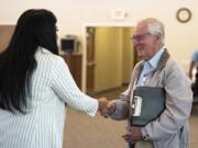 Aerotek recruiter Krti Hariharan, left, talks with Lew Olsen of Vancouver during a hiring event for job seekers in the 50-and-older age group hosted by Goodwill Industries on Wednesday.