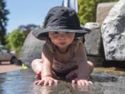 Skylar Tumm, 8 months, inspects the kid-friendly water feature at Esther Short Park on Wednesday afternoon. Unlike local rivers and streams, its water is relatively warm — and chlorinated. The feature, in the park’s southeast corner, is popular with hot kids on warm days.