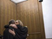 Washington Court of Appeals Judge Rich Melnick, left, hugs Judge Jennifer Snider following her swearing-in ceremony Thursday at the Clark County Courthouse.