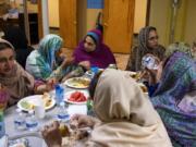 A group of women chat while eating iftar, the post-sunset meal during Ramadan, at the Islamic Society of Southwest Washington in Hazel Dell. Nighttime is also when practicing Muslims get their fill of water and other beverages.