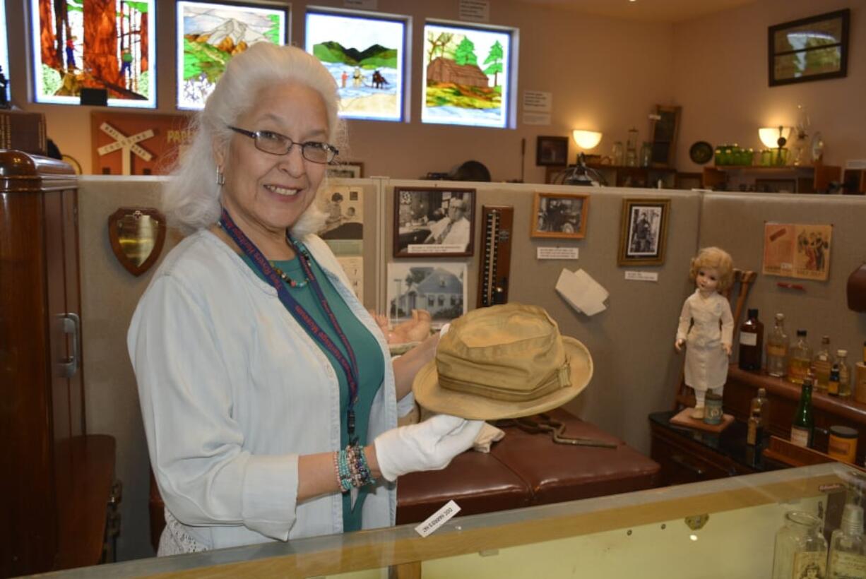 Two Rivers Heritage Museum Accession Curator Gayle Godtilbsen with the hat worn on the sidelines by Camas physician Doc Harris. The museum is seeking other historical artifacts with local significance.