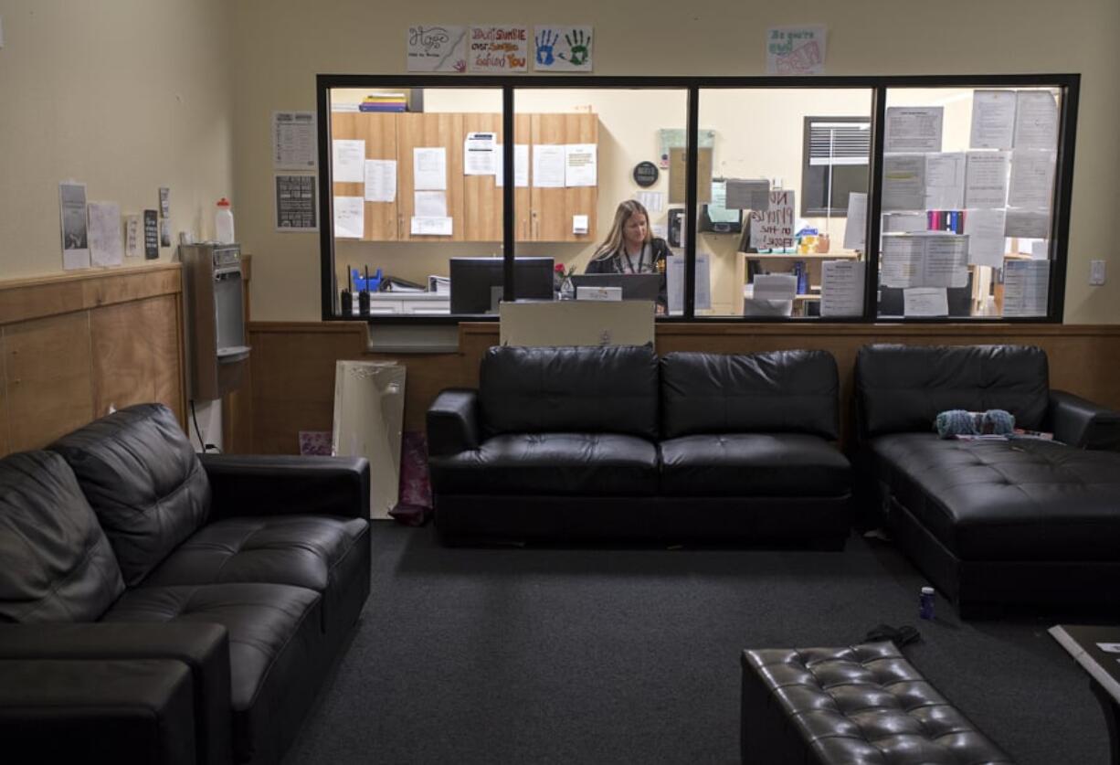 Regina Somerville, daytime shift lead at Daybreak Youth Services, works in the staff and nurses station near the common living area for girls at the Brush Prairie facility Tuesday morning.