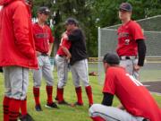 Camas head coach Stephen Short, center, consoles players after their loss to Issaquah at Propstra Stadium on Saturday afternoon, May 18, 2019. The Eagles defeated the Papermakers 5-1.