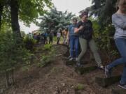 Vancouver resident Toree Hiebert, in green pants, leads a group through her backyard Wednesday afternoon before becoming the first person in Clark County to achieve silver certification under the Backyard Habitat Certification Program.